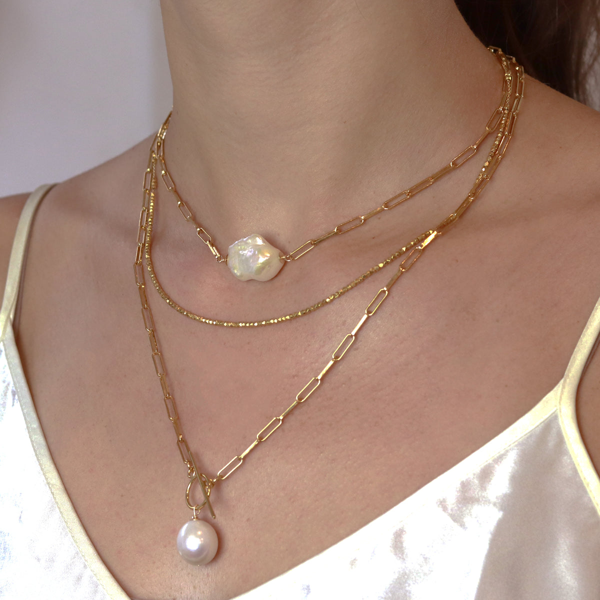 Elegant gold layering necklace, perfect for creating a chic, stacked look or wearing alone for a subtle statement.