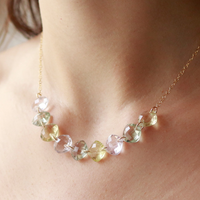 Model showcasing a multi-cushion-cut gemstone necklace, highlighting its colorful and elegant design.