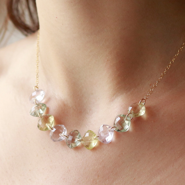 Model showcasing a multi-cushion-cut gemstone necklace, highlighting its colorful and elegant design.