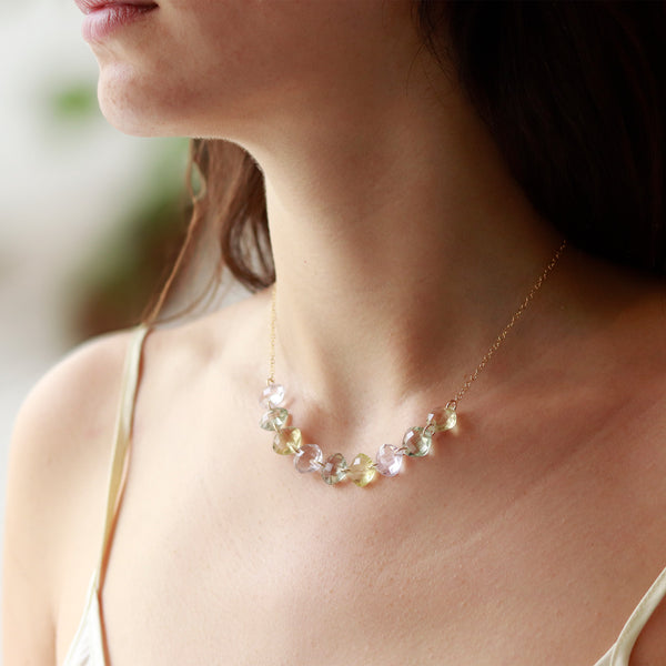 Model wearing a multi-cushion-cut gemstone necklace, showcasing vibrant gemstones in a stunning design.