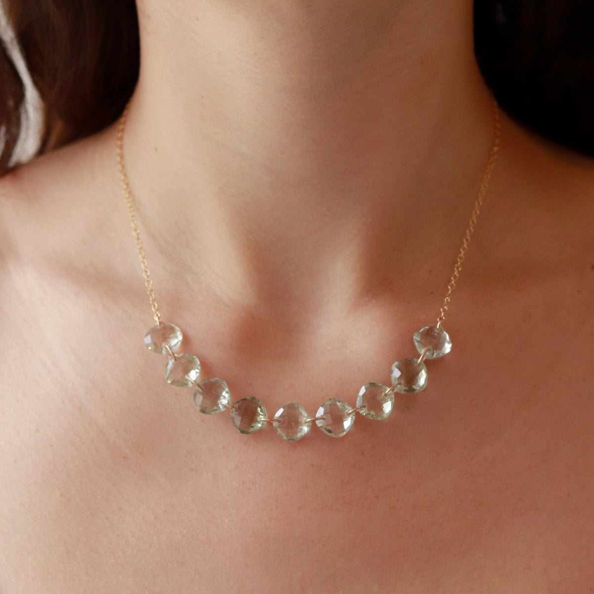 Model showcasing a multi-cushion-cut gemstone necklace with green amethyst, designed for an elegant and vibrant look.