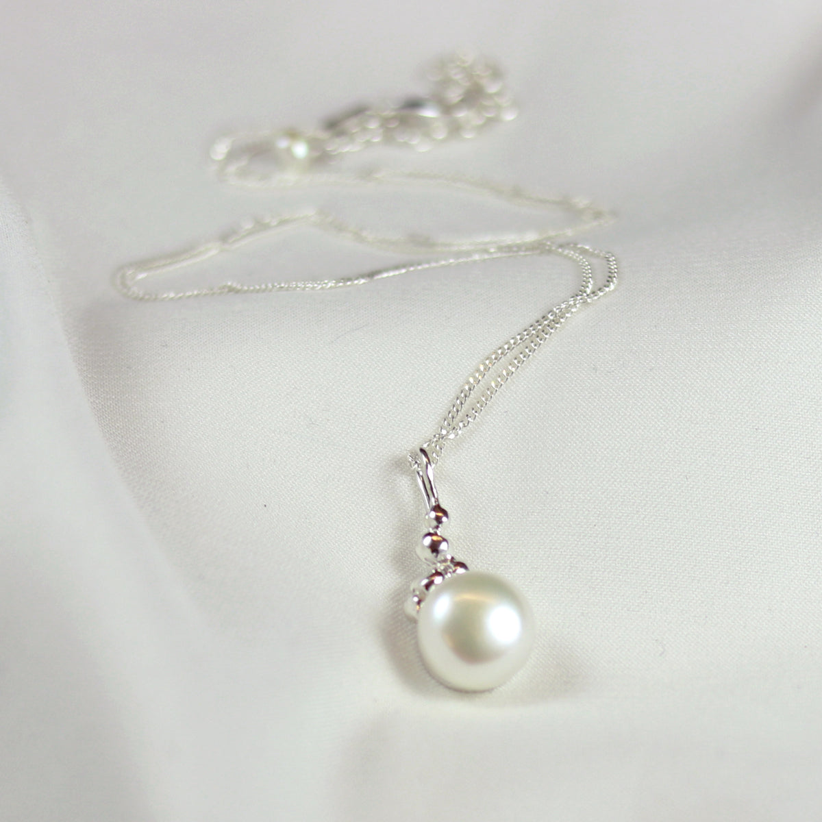 Elegant cabochon-style necklace featuring a smooth white pearl, perfect for adding a timeless touch to any jewelry collection.