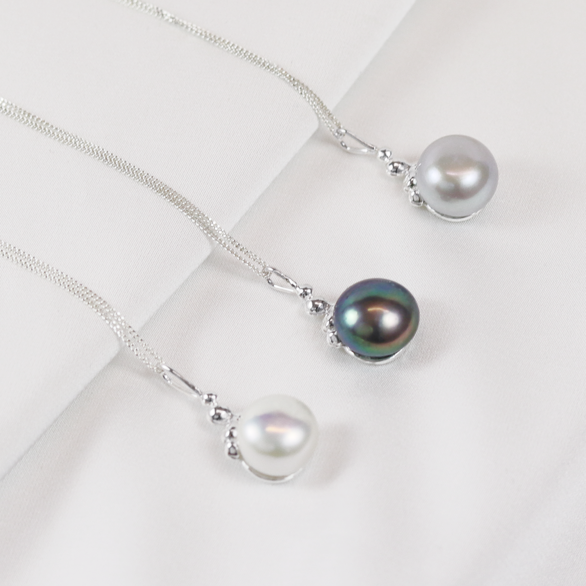 Silver textured pendant earrings featuring a lustrous pearl accent, perfect for adding a sophisticated touch to any outfit.