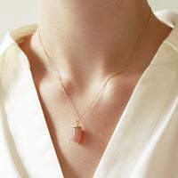 Smooth capsule pendant necklace worn on model, featuring a sleek and minimalist design perfect for everyday elegance.