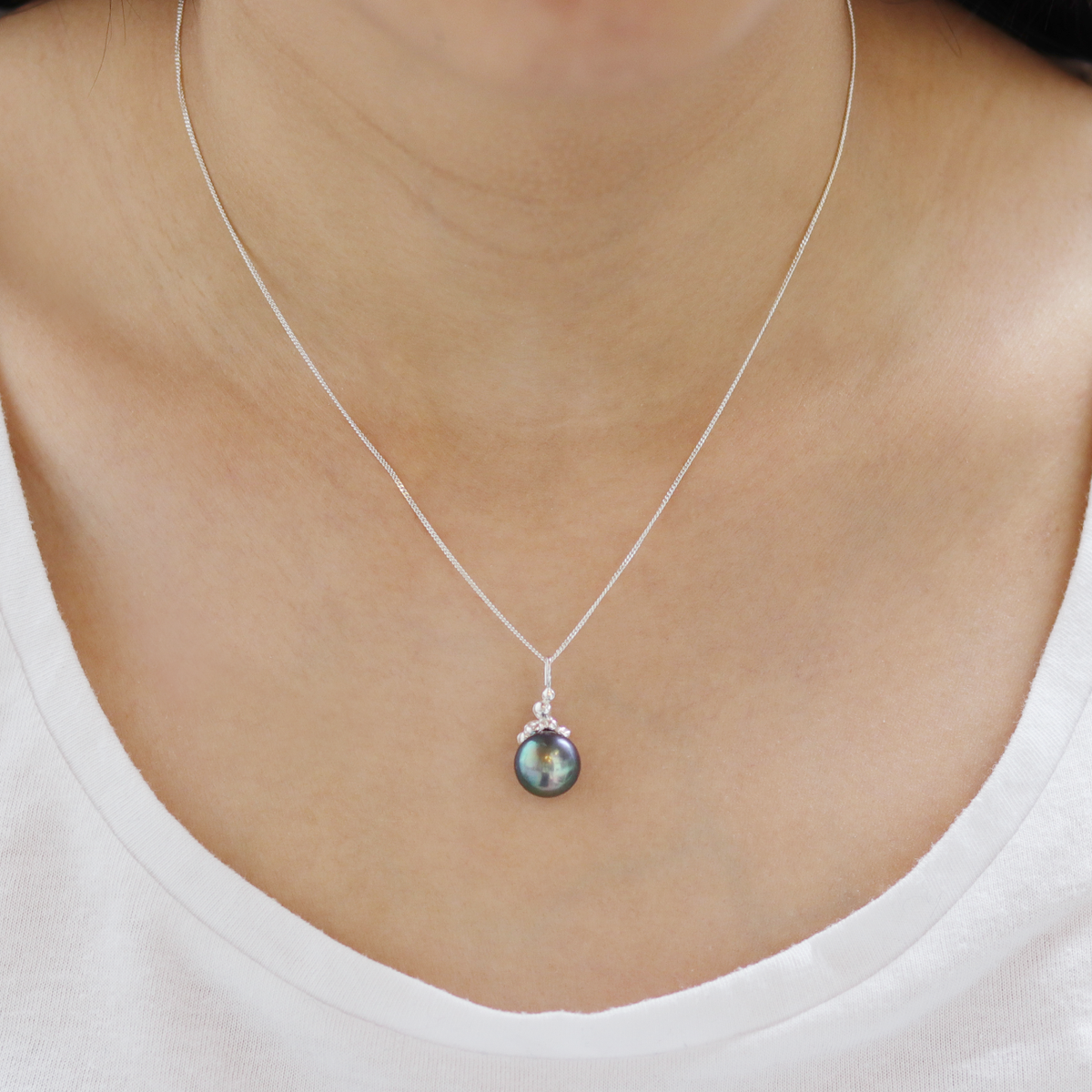 Model showcasing a sterling silver peacock pendant necklace, featuring detailed craftsmanship and a vibrant design, perfect for making a statement.