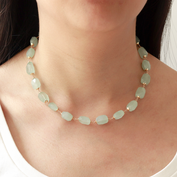 Tumbled gemstone necklace worn on model, featuring natural gemstones in vibrant aqua hues, creating a chic and earthy look that complements any outfit.